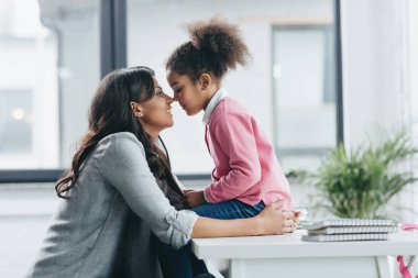 mother able to kiss little daughter clipart