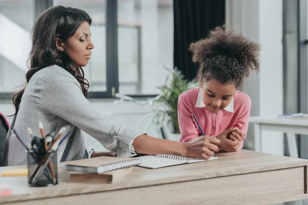 Madre ayudando a su hija con la tarea — Foto de Stock