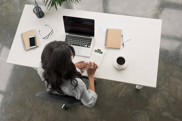 businesswoman using calculator on workplace