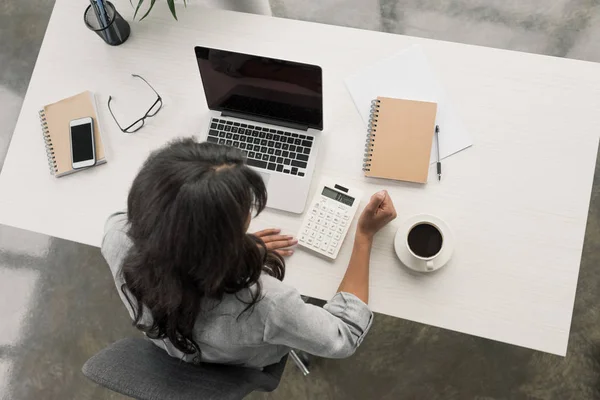 Mujer de negocios usando calculadora en el lugar de trabajo —  Fotos de Stock