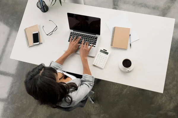 Mujer de negocios escribiendo en el ordenador portátil mientras está sentado en el lugar de trabajo —  Fotos de Stock