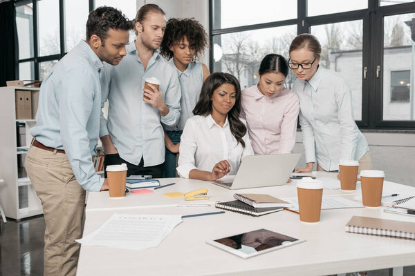 multiethnic businesspeople working with laptop