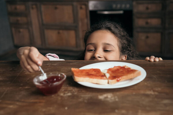 girl looking at jam in bowl