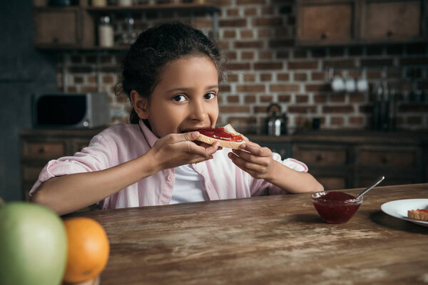 girl eating toast with jam