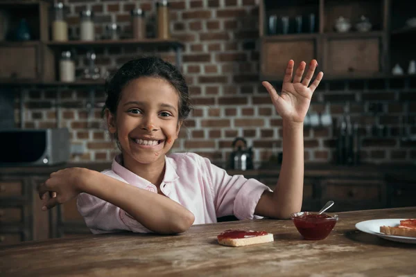 Smiling girl with hands in jam — Stock Photo, Image