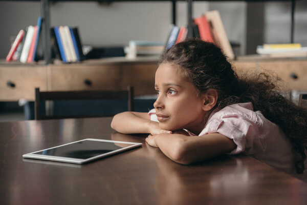 pre-adolescent girl sitting at table