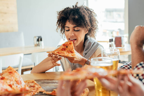 woman eating pizza in cafe
