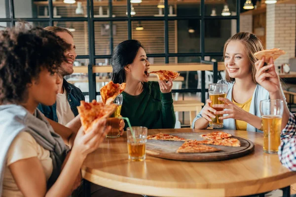 Amigos comiendo pizza en la cafetería — Foto de Stock