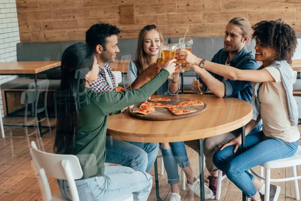 Vrienden rammelende met bier in café — Stockfoto