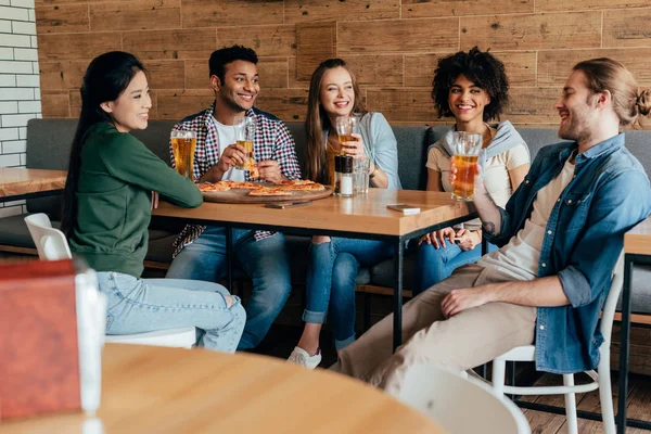 Vrienden eten pizza met bier in café — Stockfoto