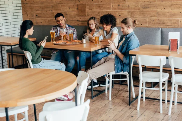 Amigos con dispositivos digitales en la cafetería — Foto de Stock