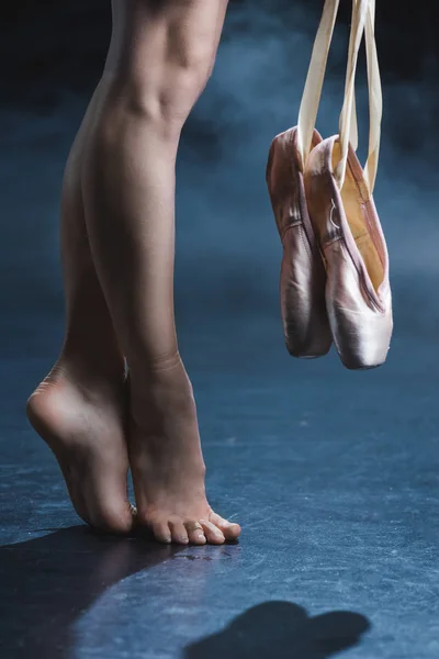 Barefoot ballerina holding pointe shoes — Stock Photo, Image