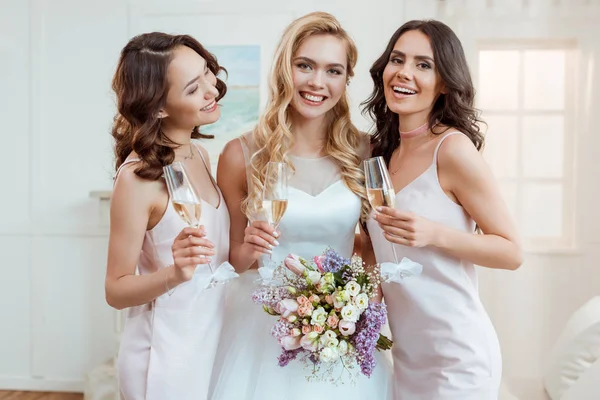 Bruid met de bruidsmeisjes drinken champagne — Stockfoto