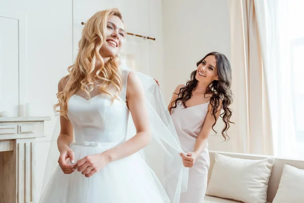 Bridesmaid preparing bride for ceremony — Stock Photo, Image