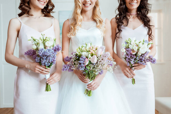 bride with bridesmaids holding bouquets