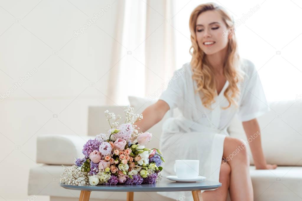 woman on sofa with wedding bouquet