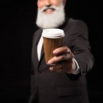 Businessman holding out coffee