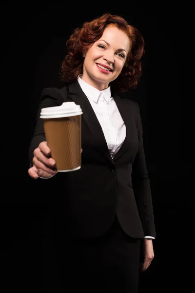Businesswoman holding out coffee cup — Free Stock Photo
