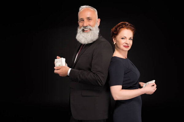 Man and woman holding bundles of money