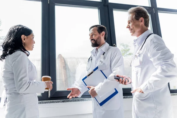 Doctors talking and drinking coffee — Stock Photo, Image