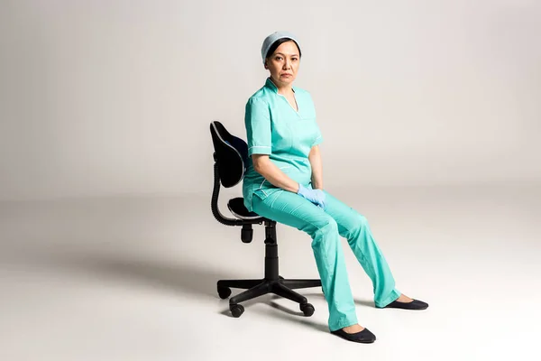 Asian doctor sitting on chair — Stock Photo, Image