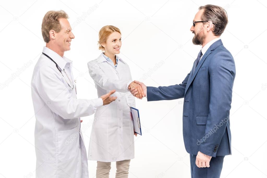 smiling businessman and doctors 