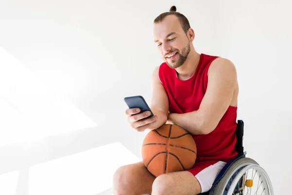 使用智能手机的残疾的篮球运动员 — 图库照片