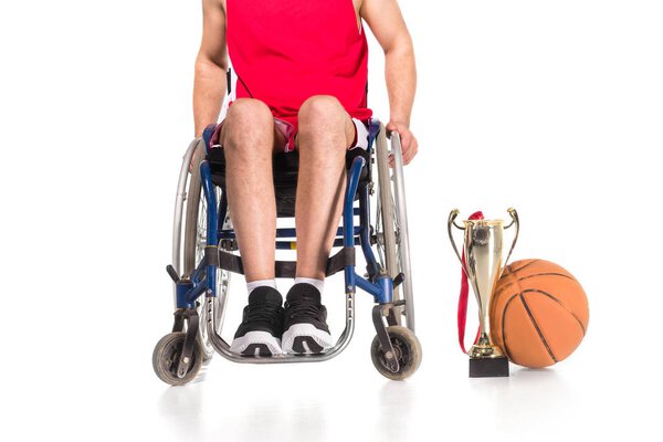 Спортсмен в инвалидной коляске с трофеями
  