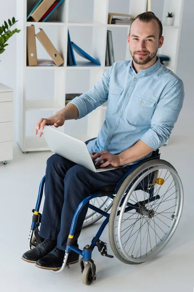 Affärsman i rullstol med laptop — Stockfoto