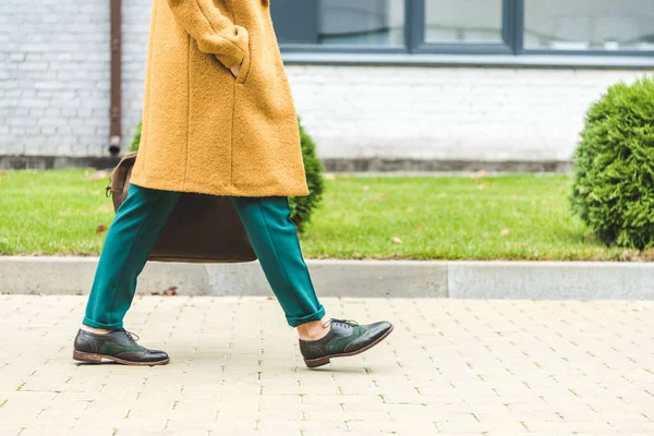 Vrouw met gele vacht wandelen in het park — Stockfoto