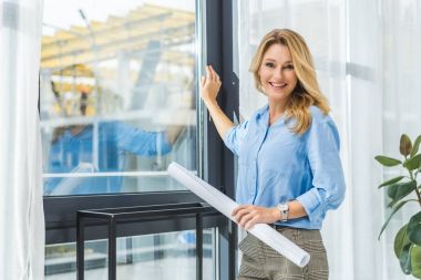 businesswoman with blueprint at window clipart