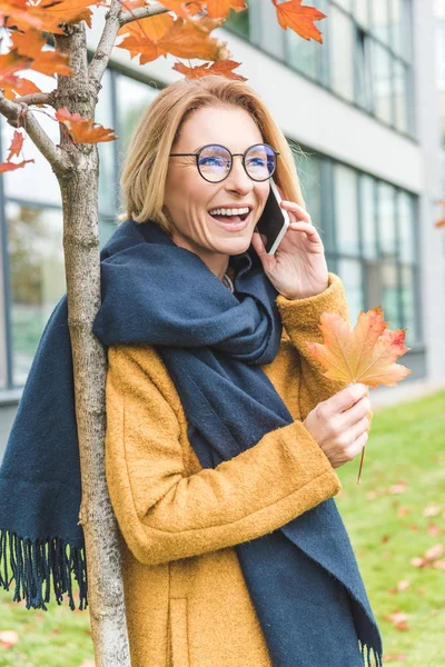 Kvinna med smartphone i höstparken — Stockfoto