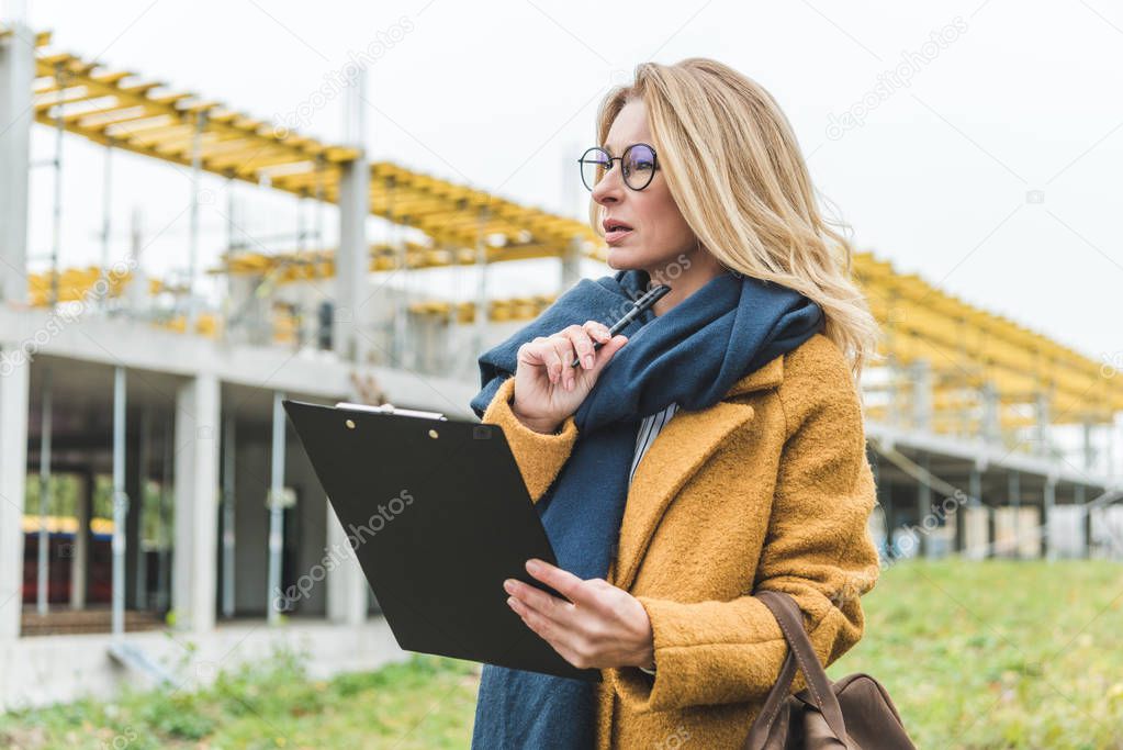 businesswoman with clipboard working on construction