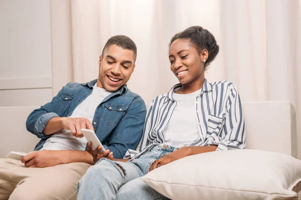 Africano casal americano sentado com smartphones — Fotografia de Stock