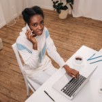 Vrouw met behulp van laptop en praten over telefoon
