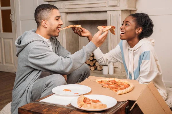 Casal compartilhando fatias de pizza — Fotografia de Stock