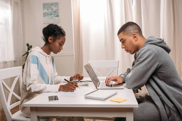 Paar benutzt Laptop und Taschenrechner — Stockfoto