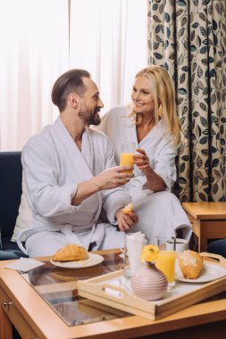 Olgun çift otel odasında birlikte kahvaltı bornoz içinde gülümseyen 