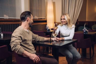 şarap içme ve diğer her otel restoranında gülümseyen güzel orta yaşlı çift   