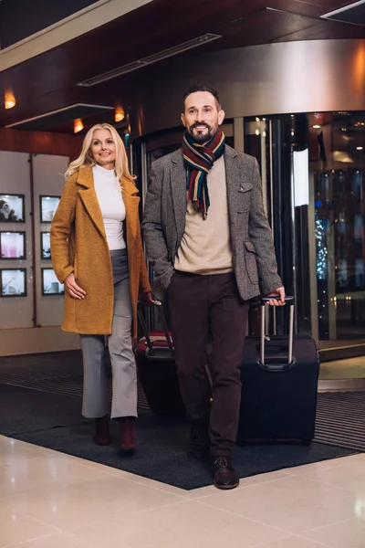 微笑成熟夫妇与手提箱离开旅馆 — 图库照片