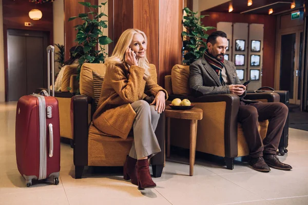 Ehepaar Mittleren Alters Benutzt Smartphones Beim Warten Mit Koffern Hotel — Stockfoto