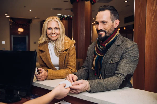 Hermosa Mujer Madura Sosteniendo Teléfono Inteligente Sonriendo Cámara Mientras Hombre — Foto de Stock