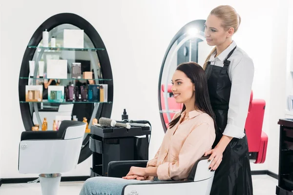 幸せな美容師と顧客の新しい髪型を見て — ストック写真