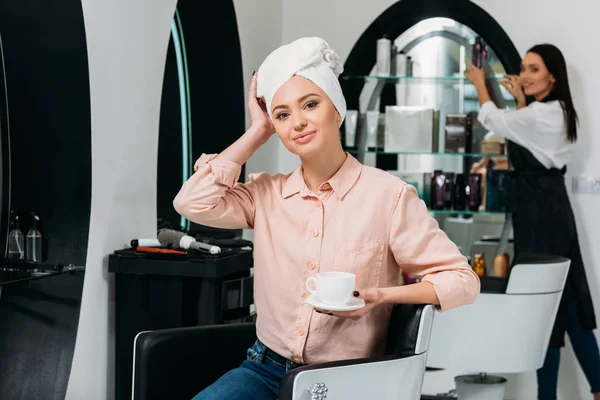 Klient Ręcznikiem Głowie Siedzi Trzymając Kubek Kawy Salon Fryzjerski — Zdjęcie stockowe