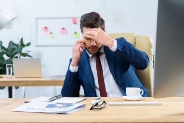 Smartphone ile konuşmak ve baş ağrısı olan yorgun işadamı