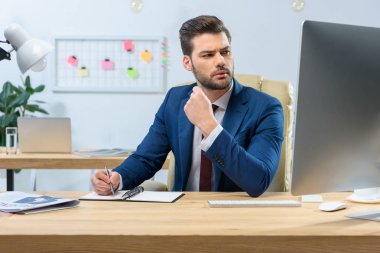 kalem tutan ve uzağa bakarak konsantre işadamı
