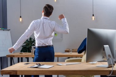 Arkadan ayakta ve ofiste germe işadamı görünüşü