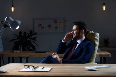 Smartphone ile konuşmak ve uzağa bakarak gülümseyen iş adamı