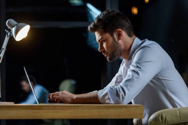 Akşamları laptop çalışma işadamı yan görünüm