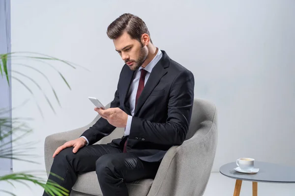 Biznesmen Siedząc Fotelu Ogląda Smartphone — Zdjęcie stockowe